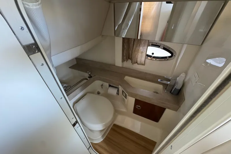 Slide: The Image of 2016 Formula 350 Crossover Bowrider I/O bathroom with sink, toilet, and mirror. - 62
