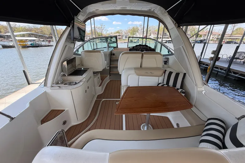 Slide: The Image of 2008 Sea Ray Sundancer 330 interior with seating, table, and kitchenette by the water. - 10