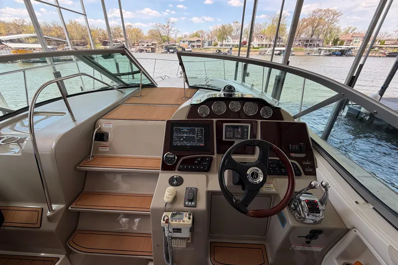 Slide: The Image of 2008 Sea Ray Sundancer 330 helm with modern controls and scenic waterfront view. - 16