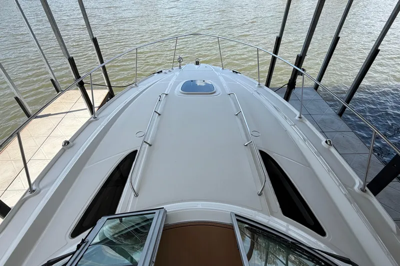 Slide: The Image of 2008 Sea Ray Sundancer 330 yacht docked, showcasing sleek deck design and water view. - 6