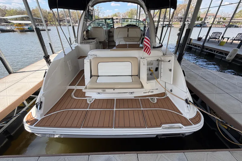 Slide: The Image of 2008 Sea Ray Sundancer 330 docked, featuring spacious deck and seating, with American flag. - 9