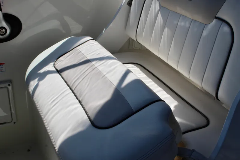 Slide: The Image of 2011 Sea Ray Sundancer 260 interior seating with white upholstery and black trim. - 19