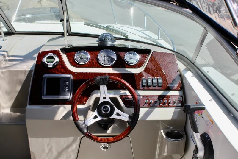 Slide: The Image of Cockpit of 2011 Sea Ray Sundancer 260 with wood accents and modern controls. - 21