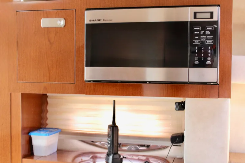 Slide: The Image of 2011 Sea Ray Sundancer 260 interior with microwave and storage cabinet. - 23