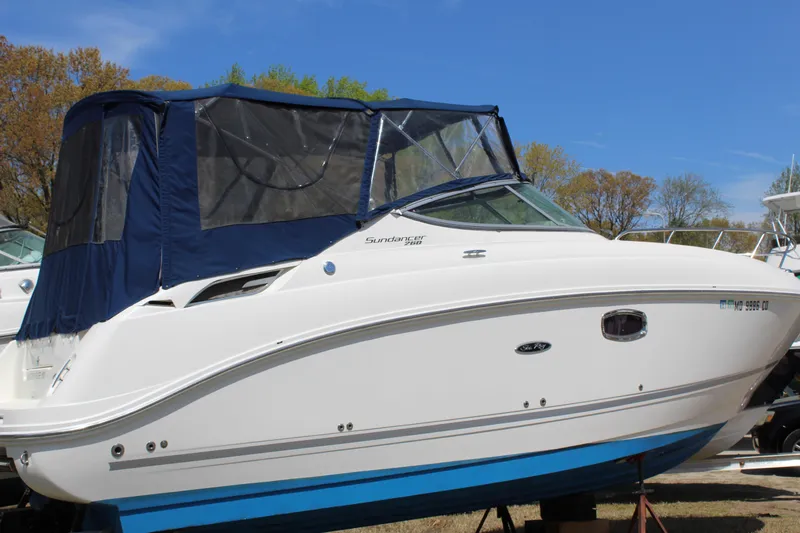 Slide: The Image of 2011 Sea Ray Sundancer 260 boat with blue canopy, displayed outdoors. - 7