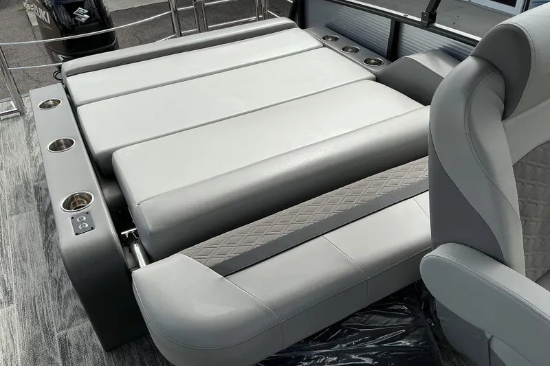 Slide: The Image of Luxurious seating on 2026 Qwest L-Class Splash Pad 24 pontoon boat, featuring cup holders. - 11