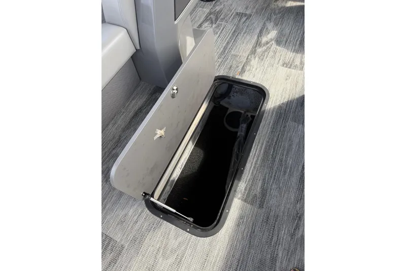 Slide: The Image of Open storage compartment on 2026 Qwest L-Class Splash Pad 24 boat, featuring sleek interior design. - 17