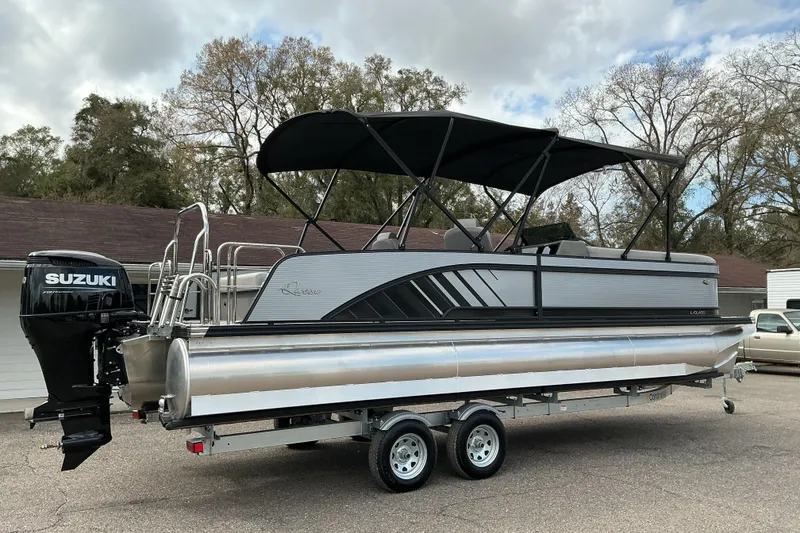 Slide: The Image of 2026 Qwest L-Class Splash Pad 24 pontoon boat with Suzuki outboard motor on trailer. - 2