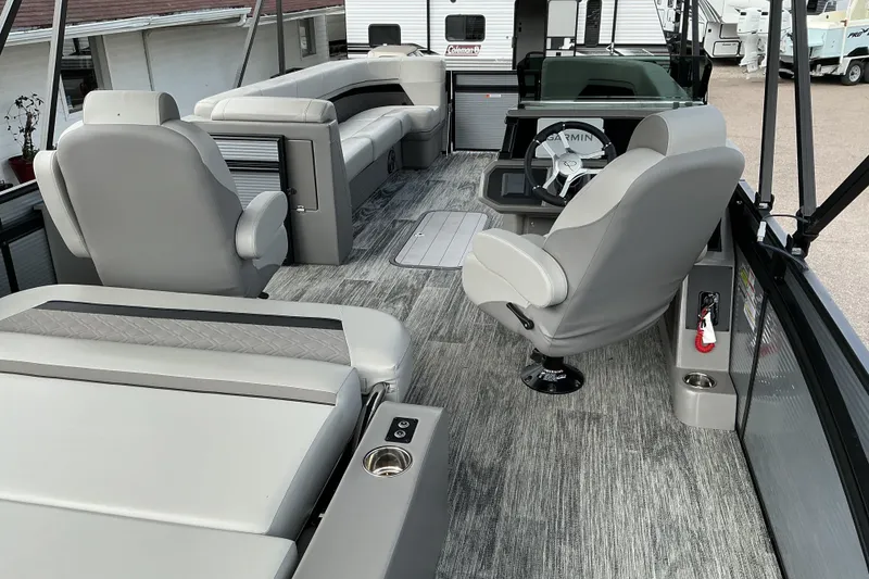 Slide: The Image of 2026 Qwest L-Class Splash Pad 24 pontoon boat interior with modern seating and steering console. - 8