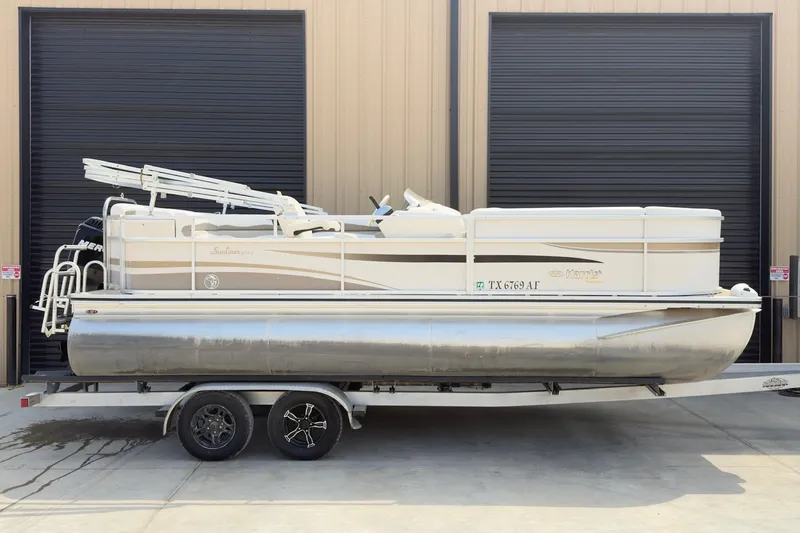 The Image of 2007 Harris Sunliner 220 pontoon boat on trailer, parked in front of a garage. - 1