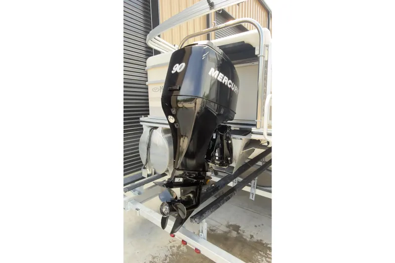 Slide: The Image of 2007 Harris Sunliner 220 with Mercury 90 outboard motor, docked in a storage area. - 5