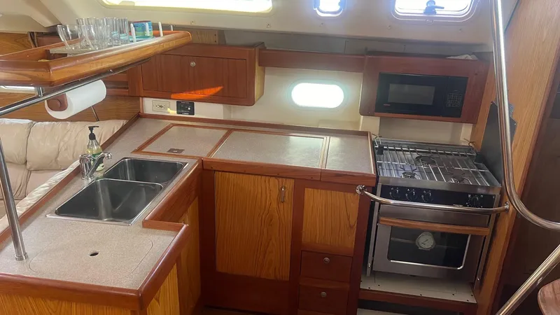 Slide: The Image of Interior of a 2000 Hunter 410 sailboat kitchen with sink, stove, and microwave. - 11