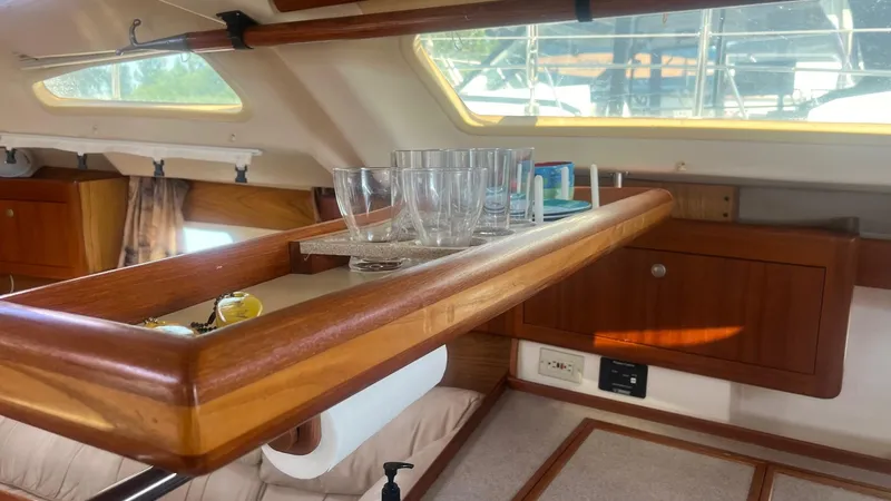 Slide: The Image of Interior of a 2000 Hunter 410 sailboat with wooden cabinetry and glassware. - 15