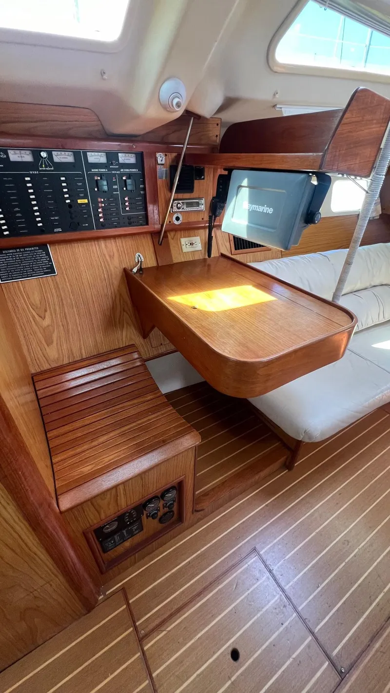 Slide: The Image of Interior of 2000 Hunter 410 sailboat with wooden table and navigation equipment. - 16