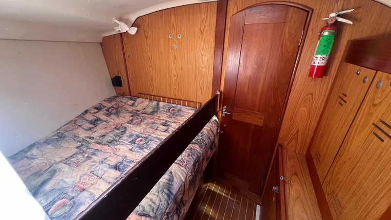Slide: The Image of Cozy cabin interior of 2000 Hunter 410 sailboat with wood paneling and patterned bedding. - 20