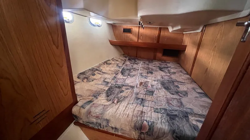 Slide: The Image of Cozy cabin interior of 2000 Hunter 410 sailboat with wood paneling and patterned bedding. - 23
