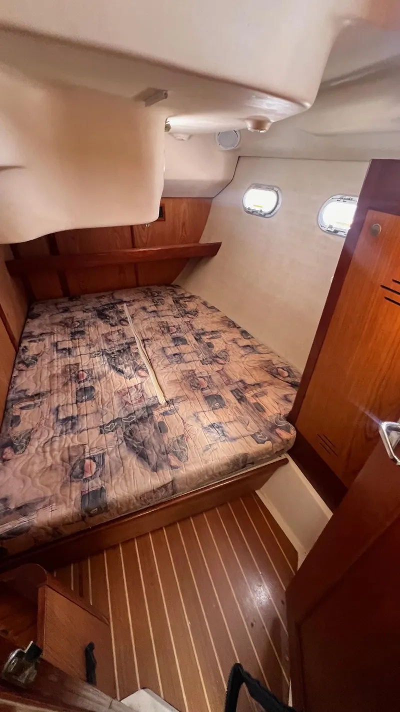 Slide: The Image of Cozy cabin interior of 2000 Hunter 410 sailboat with wood accents and patterned bedding. - 24