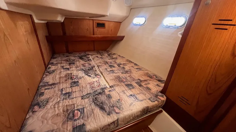 Slide: The Image of Cozy cabin interior of 2000 Hunter 410 sailboat with wooden accents and patterned bedding. - 25