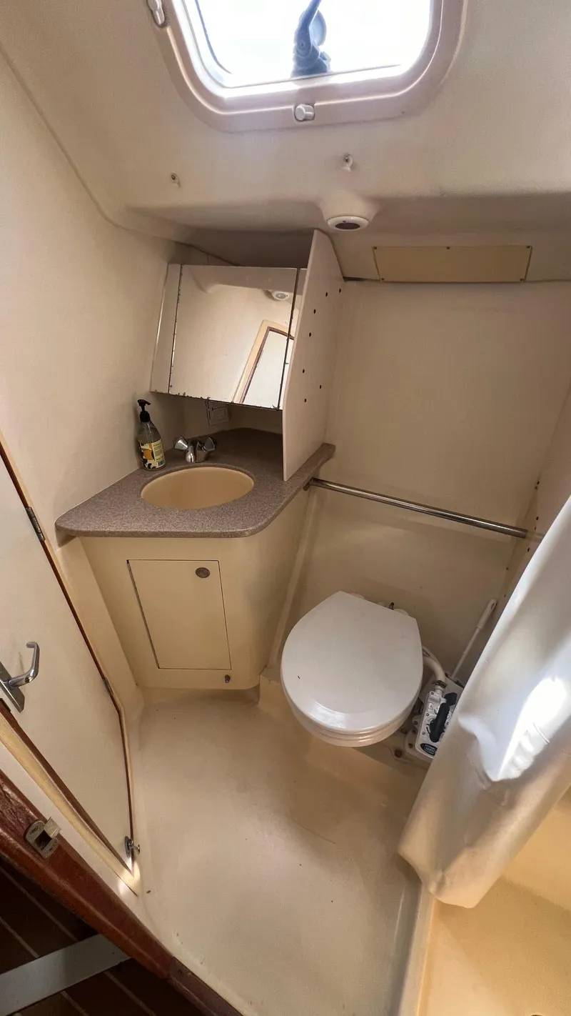Slide: The Image of Compact bathroom in 2000 Hunter 410 sailboat with sink, toilet, and mirror. - 31