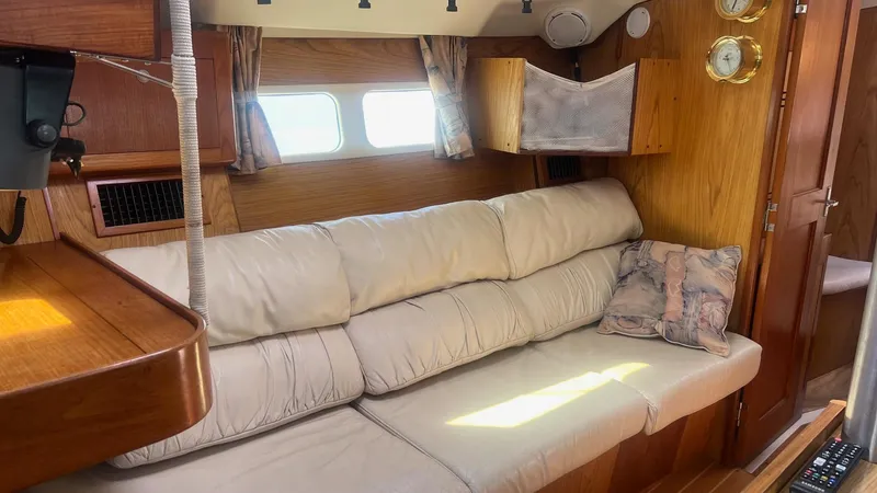 Slide: The Image of Interior of a 2000 Hunter 410 yacht with a cozy beige sofa and wooden accents. - 5
