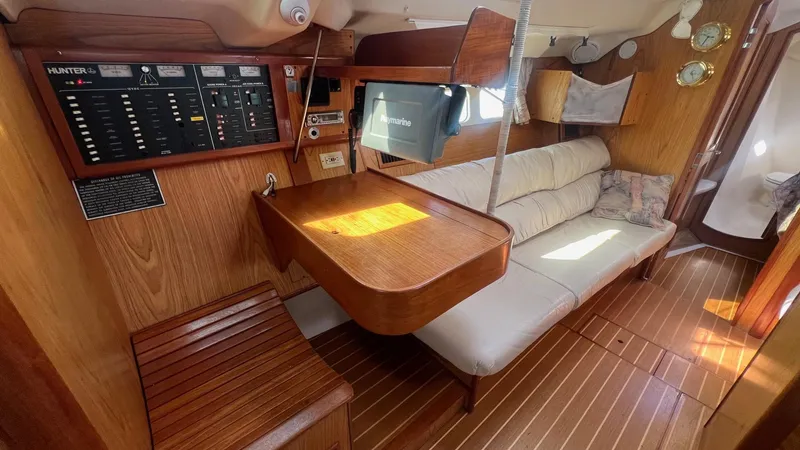 Slide: The Image of Interior of 2000 Hunter 410 sailboat with wood paneling, seating, and navigation equipment. - 6