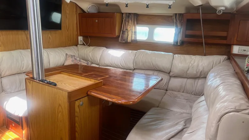 Slide: The Image of Cozy interior of 2000 Hunter 410 sailboat with plush seating and wooden table. - 7