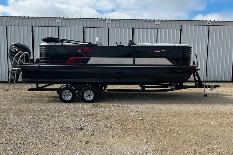 The Image of 2025 SunCatcher ELITE 324RC pontoon boat on trailer, parked outdoors. - 1