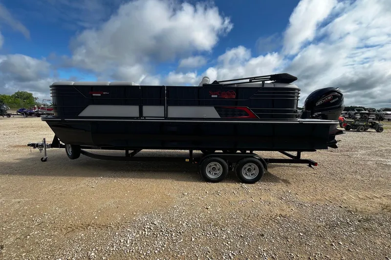 Slide: The Image of 2025 SunCatcher ELITE 324RC pontoon boat on trailer under cloudy sky. - 5