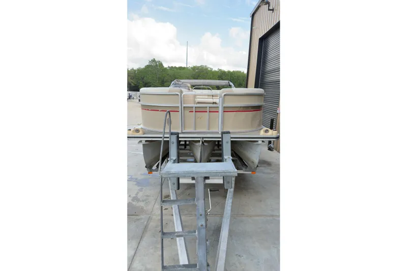Slide: The Image of 2008 Harris Super Sunliner 220 pontoon boat on trailer near a warehouse. - 9