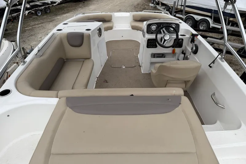 Slide: The Image of 2016 Hurricane SunDeck Sport 188 IO boat interior with beige seating and steering console. - 2