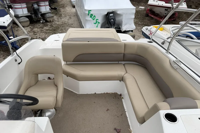 Slide: The Image of 2016 Hurricane SunDeck Sport 188 IO boat interior with beige seating and steering wheel. - 4