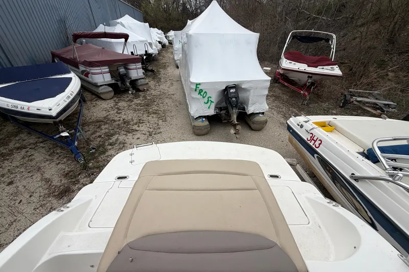 Slide: The Image of Boats stored outdoors, including a 2016 Hurricane SunDeck Sport 188 IO, covered for protection. - 6