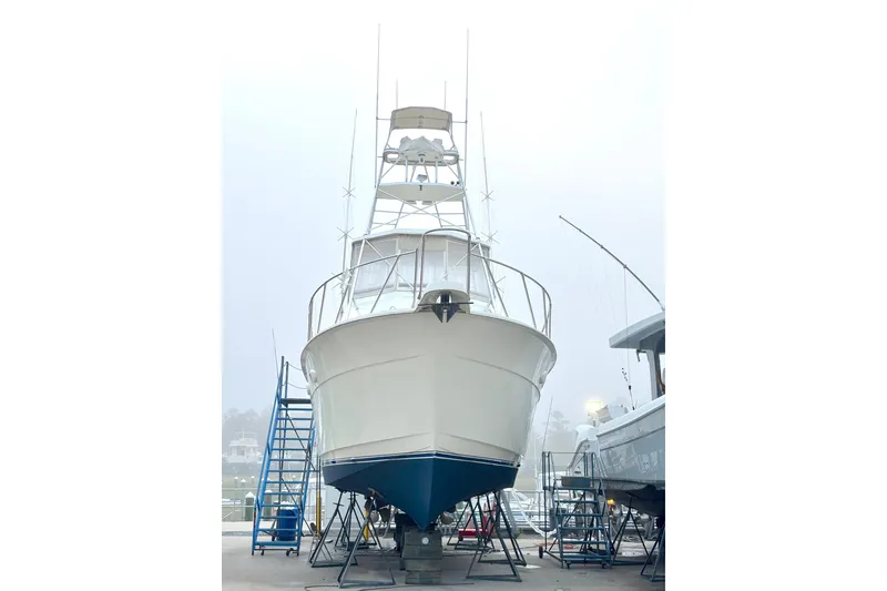 Slide: The Image of 1989 Hatteras 45 Convertible yacht on dry dock with ladders and foggy background. - 5