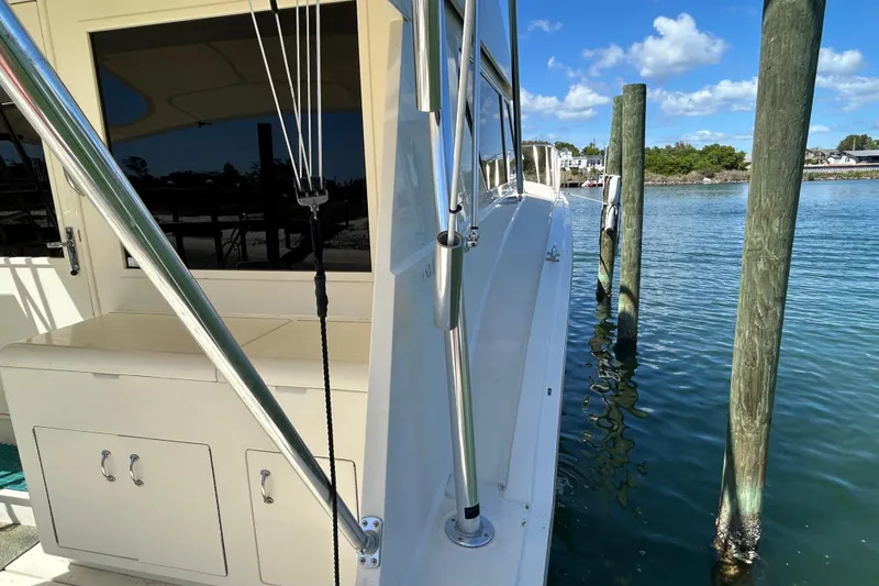 Slide: The Image of 1989 Hatteras 45 Convertible yacht docked by wooden posts on a sunny day. - 18