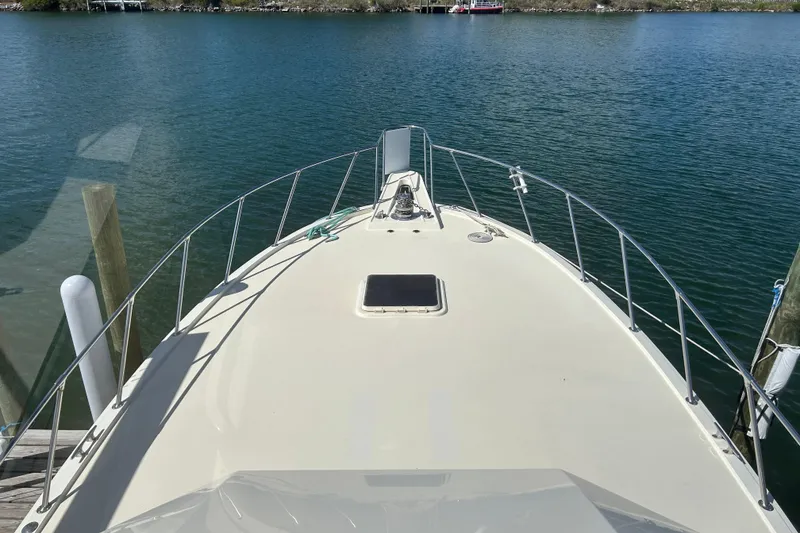 Slide: The Image of 1989 Hatteras 45 Convertible yacht bow view on calm water. - 11