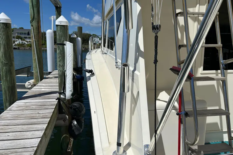 Slide: The Image of 1989 Hatteras 45 Convertible yacht docked at marina with clear blue sky. - 12