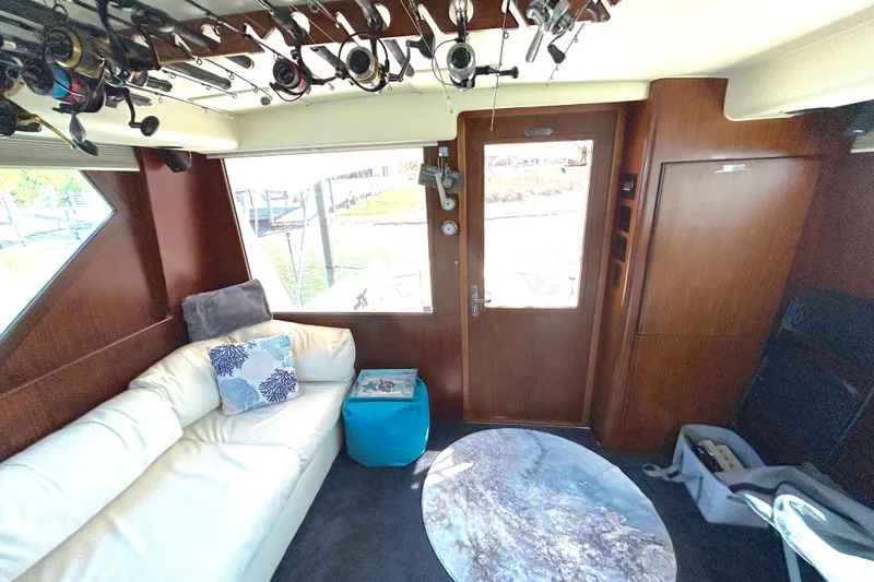 Slide: The Image of Interior of 1989 Hatteras 45 Convertible yacht with fishing rods and cozy seating. - 19