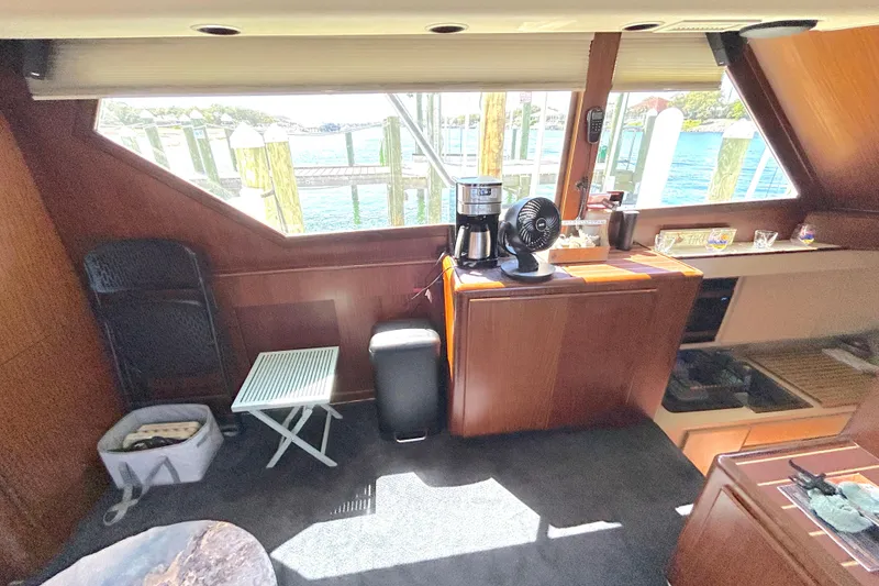 Slide: The Image of Interior of 1989 Hatteras 45 Convertible yacht with wooden cabinetry and waterfront view. - 26