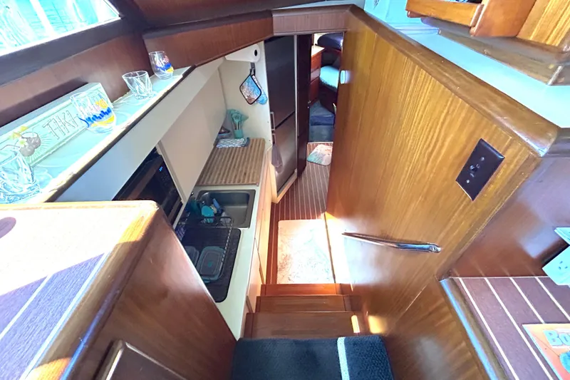 Slide: The Image of Interior of 1989 Hatteras 45 Convertible yacht with wooden cabinetry and compact kitchen area. - 22