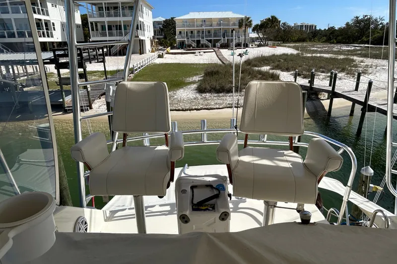 Slide: The Image of Two captain chairs on a 1989 Hatteras 45 Convertible yacht overlooking a waterfront property. - 61