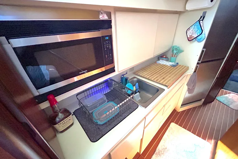 Slide: The Image of Compact kitchen area in a 1989 Hatteras 45 Convertible yacht with modern appliances. - 24