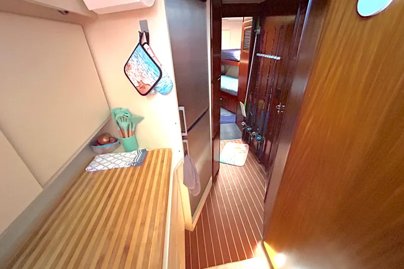Slide: The Image of Interior of 1989 Hatteras 45 Convertible yacht with wooden flooring and compact kitchen area. - 25