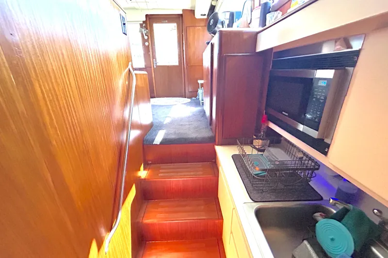 Slide: The Image of Interior of 1989 Hatteras 45 Convertible yacht with wooden stairs and kitchenette. - 27
