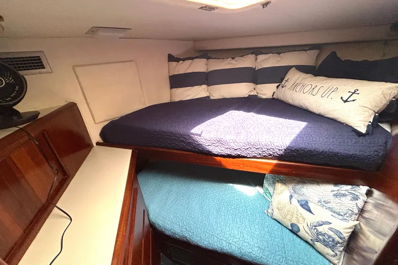 Slide: The Image of Cozy cabin interior of 1989 Hatteras 45 Convertible with nautical-themed bedding. - 29