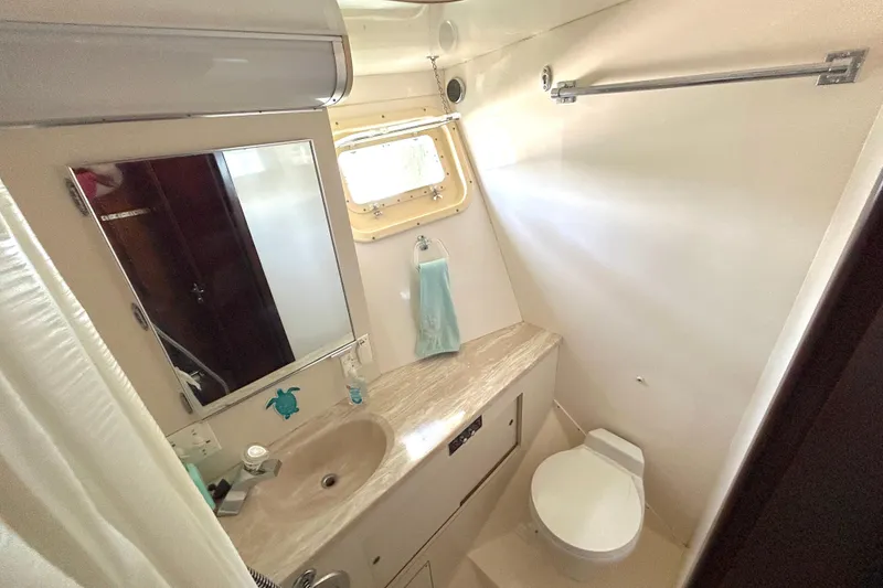 Slide: The Image of Bathroom interior of 1989 Hatteras 45 Convertible yacht, featuring sink, mirror, and toilet. - 32