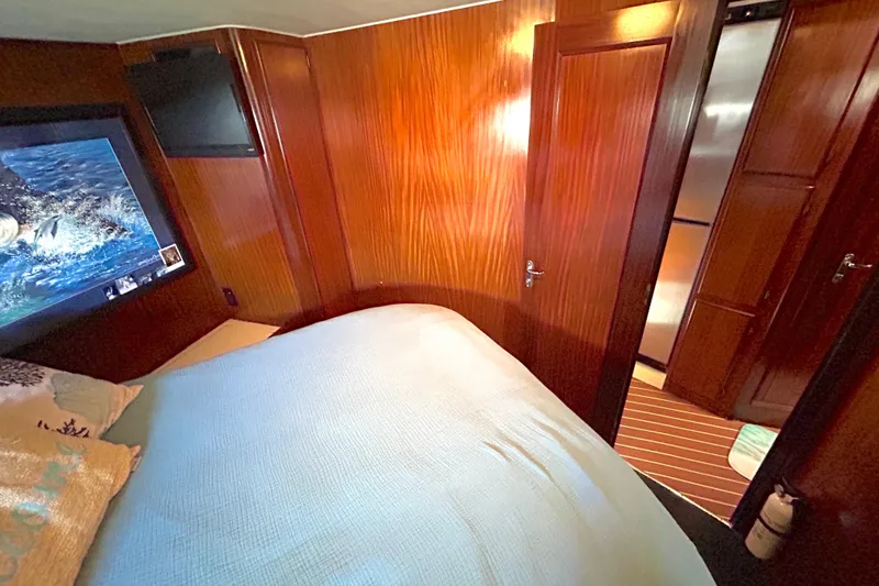 Slide: The Image of Interior of 1989 Hatteras 45 Convertible yacht bedroom with wood paneling and TV. - 37