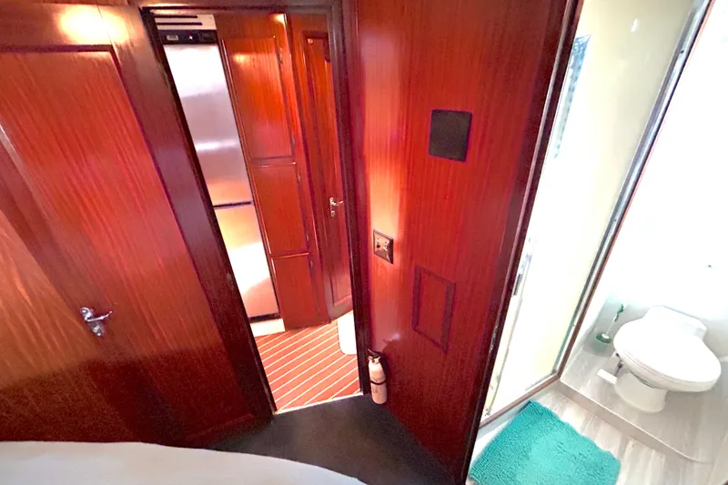 Slide: The Image of Interior of 1989 Hatteras 45 Convertible yacht, featuring wood paneling and a compact bathroom. - 38