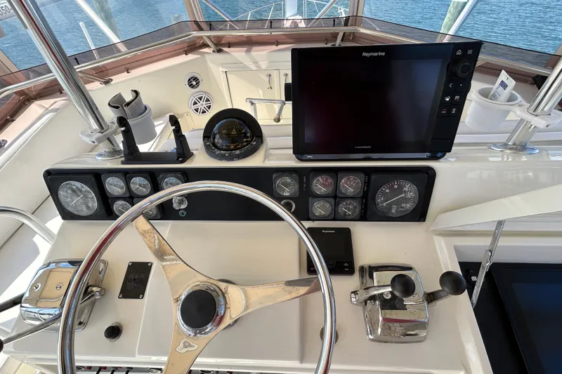 Slide: The Image of Helm of 1989 Hatteras 45 Convertible with gauges and Raymarine display. - 43