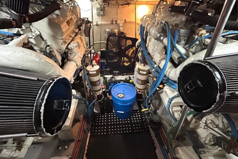 Slide: The Image of Engine room of 1989 Hatteras 45 Convertible yacht, featuring dual engines and maintenance equipment. - 48