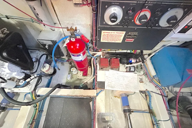 Slide: The Image of Engine room of 1989 Hatteras 45 Convertible with fire extinguisher and control panel. - 49